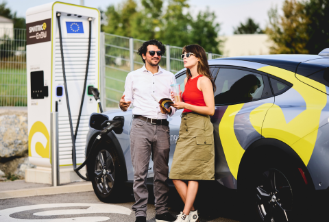 2 Personen vor E-Auto und Ladestation